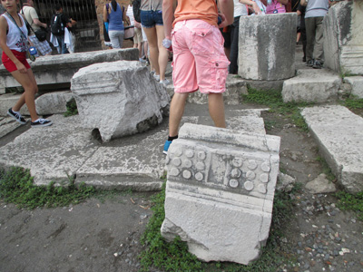 Photo shows several broken pieces of marble about two feet high and wide.  On one of the pieces are two squares, each with three rows of raised circles.